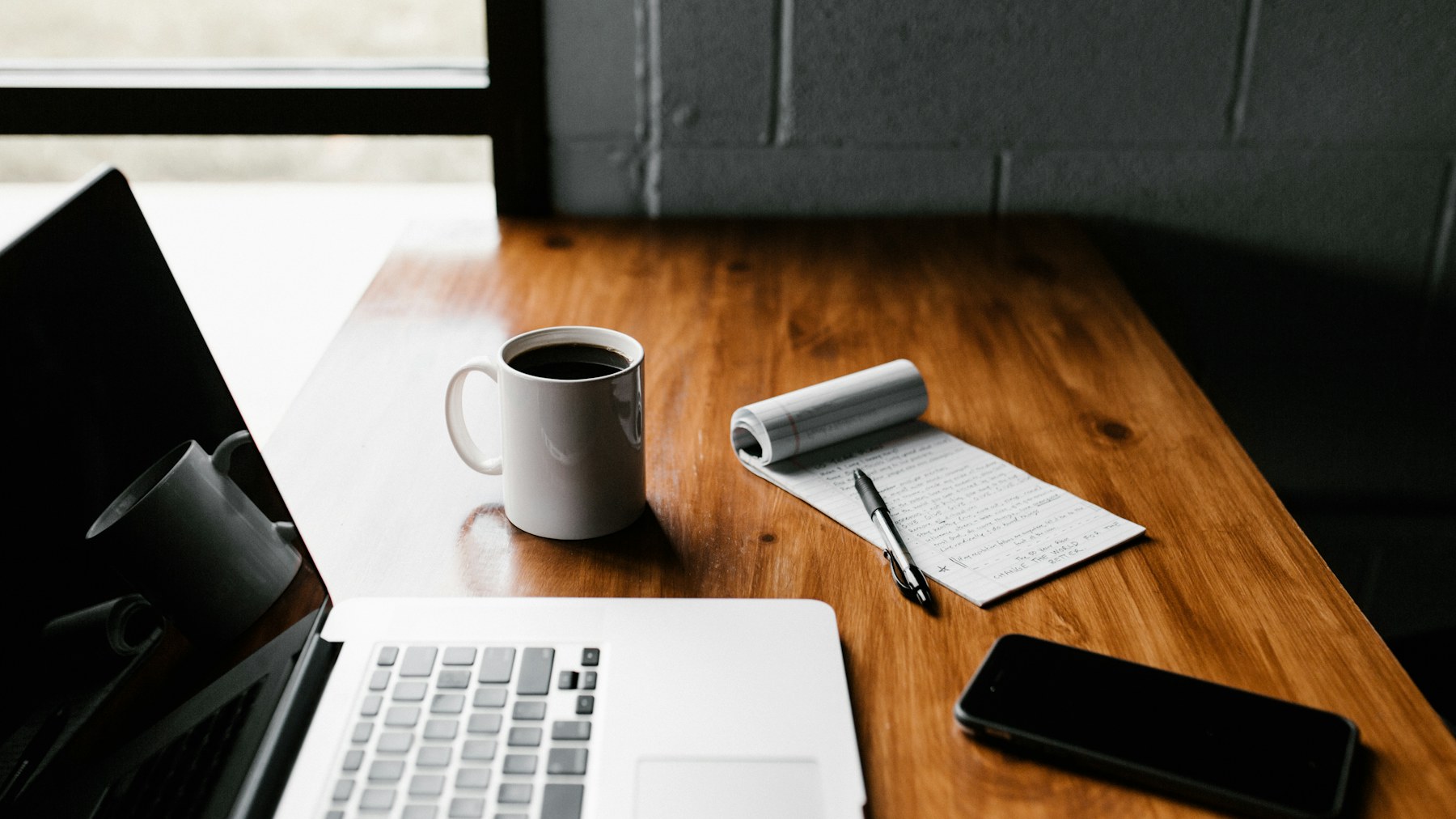 Person focused on a laptop in a bright workspace